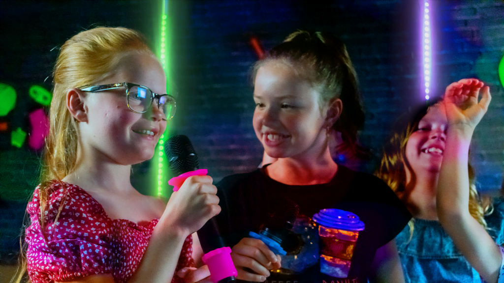 Kids enjoying karaoke at a family venue with SUNVIG's song catalog